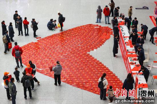 1月14日,贵州省贵阳市,旅客在贵阳北站候车大厅参与送春联、福字活动。 1月14日,贵州省贵阳市,旅客在贵阳北站候车大厅参与送春联、福字活动。