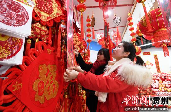 1月14日，市民正在贵阳市南明区惠民生鲜合力超市南浦路店年货大街选购新春饰品。