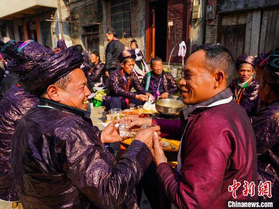 图为人们在大融村的鼓楼庆典活动中一起吃团圆宴。 卢忠南 摄