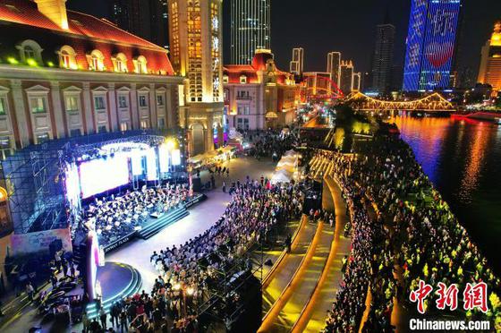 2024年4月12日晚,“‘桥’见海河,邂逅浪漫”——桥边音乐汇系列活动启动仪式在天津市津湾广场举行。图为市民及游客观看演出。(无人机照片) 记者 佟郁 摄