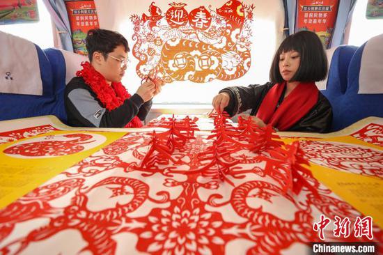 图为非遗手艺人在“村火车年货铺”展示剪纸。中新社记者 瞿宏伦 摄