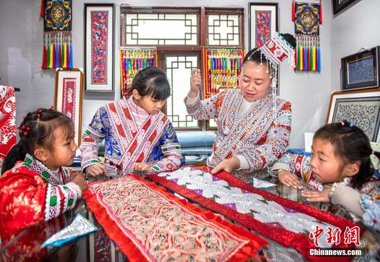 图为“童伴妈妈”杨国美在指导孩子们学习刺绣。 图为“童伴妈妈”杨国美在指导孩子们学习刺绣。