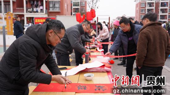 书法爱好义务为社区居民写春联和“福”字
