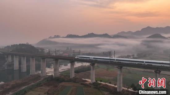 2025年1月21日，动车组列车行驶在沪昆高铁贵州省铜仁市玉屏侗族自治县境内，与晨雾、山峦、田园、村庄等交相辉映，美如画卷。胡攀学 摄