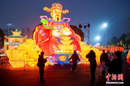 图为市民在贵阳观山湖灯会庙市现场观赏拍照。 图为市民在贵阳观山湖灯会庙市现场观赏拍照。