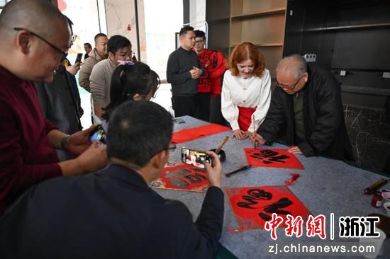 图为:民革浙江省直五支部主委田振玉写福引人观看。中新社记者 王刚 摄