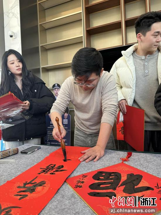 图为:民革浙江省直五支部党员应正阳书写春联。中新社发 陈出新 摄