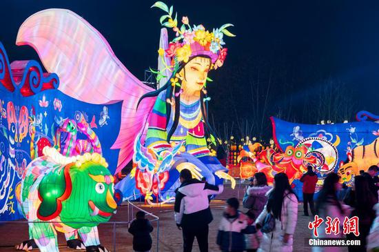 图为市民在贵阳观山湖灯会庙市现场观赏拍照。 图为市民在贵阳观山湖灯会庙市现场观赏拍照。