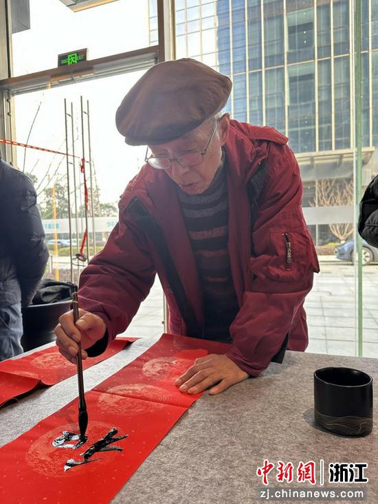 图为:民革浙江省直五支部党员徐弘道书写春联。中新社发 陈出新 摄