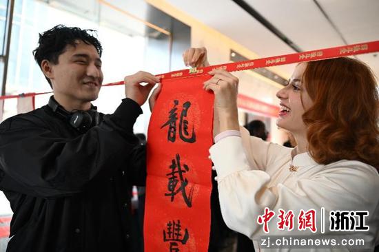 图为:参观者挂起民革浙江省直五支部党员创作的春联。中新社记者 王刚 摄