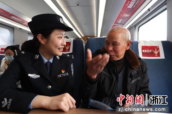 图为:铁路民警在车厢内和乘客互动。中新社发 贺瑞明 摄