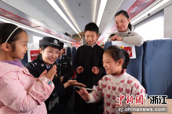 图为:铁路民警在车厢内和乘客互动。中新社发 贺瑞明 摄