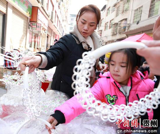在剑河县城集市上,群众在选购银饰饰品。杨家孟 摄 在剑河县城集市上,群众在选购银饰饰品。杨家孟 摄