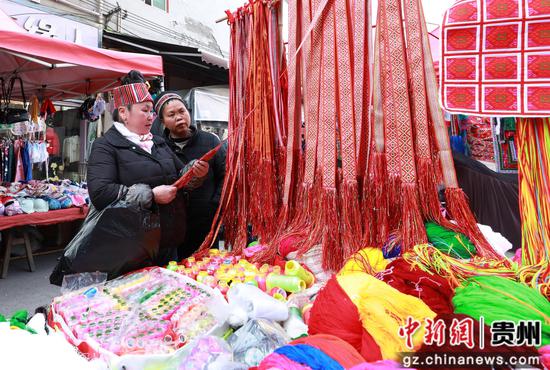 在剑河县城集市上,苗族群众在选购民族服饰饰品。杨家孟 摄 在剑河县城集市上,苗族群众在选购民族服饰饰品。杨家孟 摄