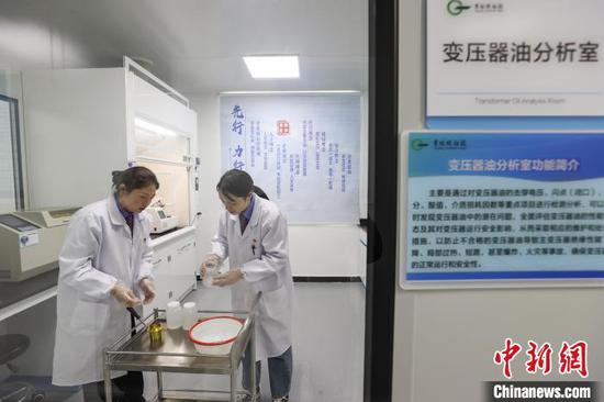 1月24日，贵州省贵阳市，“化验工”王荣兰(左)和犹静俊在进行变压器油分析。中新社记者 瞿宏伦 摄