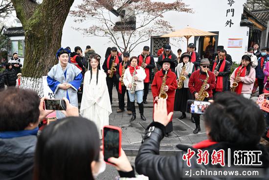 图为：民众在江南民居前吹奏新春乐曲吸引市民。中新社记者 王刚 摄