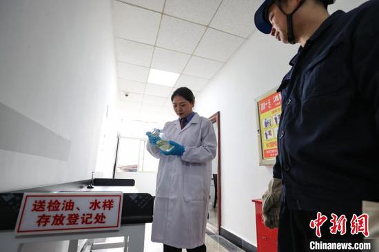 1月24日，贵州省贵阳市，“化验工”王荣兰在接收待检油料。中新社记者 瞿宏伦 摄