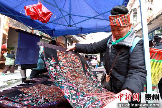 在剑河县城集市上,苗族群众在选购民族服饰饰品。杨家孟 摄 在剑河县城集市上,苗族群众在选购民族服饰饰品。杨家孟 摄