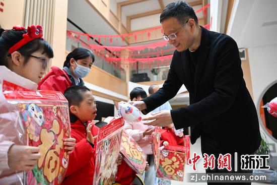 图为:中国新闻社浙江分社副社长严格在杭州市儿童福利院赠送年礼。中新社记者 王刚 摄