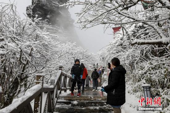 图为游客在梵净山景区赏雪游玩。 图为游客在梵净山景区赏雪游玩。