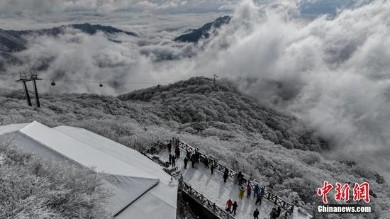 图为游客在梵净山景区赏雪游玩。 图为游客在梵净山景区赏雪游玩。