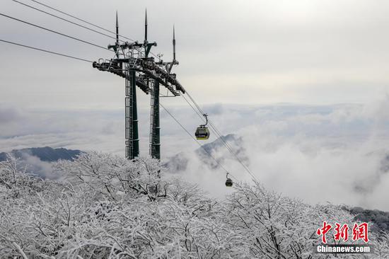 图为游客在梵净山景区乘坐缆车游玩。 图为游客在梵净山景区乘坐缆车游玩。