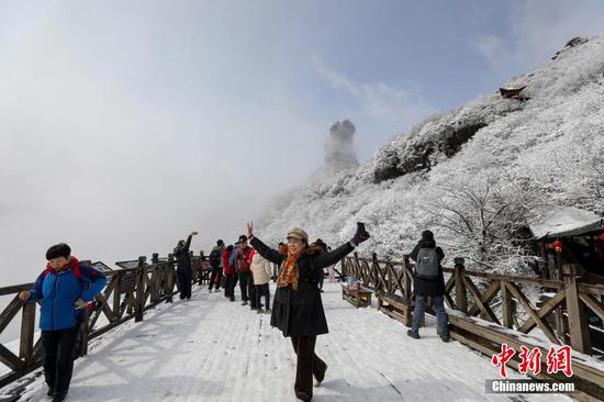 图为游客在梵净山景区赏雪游玩。 图为游客在梵净山景区赏雪游玩。