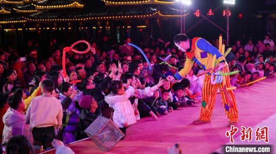 图为演员在侗乡风情园景区和游客做游戏。胡攀学 摄