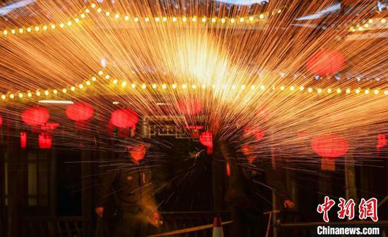 图为民间艺人在侗乡风情园景区为游客表演打铁花。 胡攀学 摄