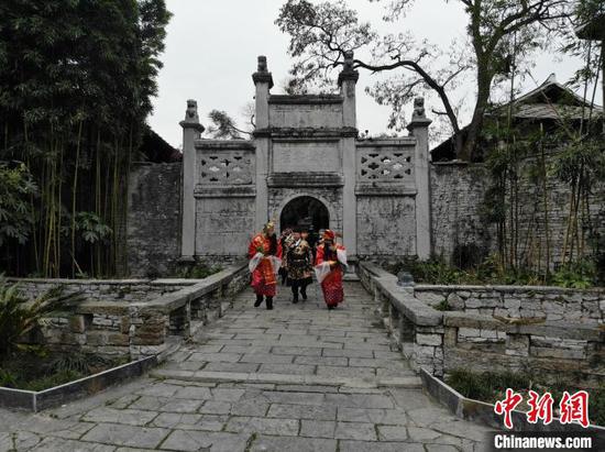 图为天龙屯堡景区工作人员装扮的“财神”等角色在“游街”。石小杰 摄 图为天龙屯堡景区工作人员装扮的“财神”等角色在“游街”。石小杰 摄