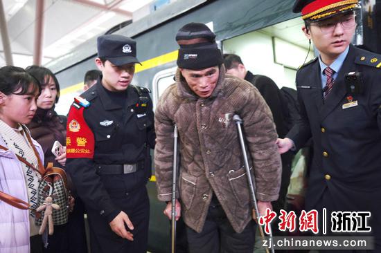 图为:乘警帮助旅客。中新社发 贺瑞明 摄