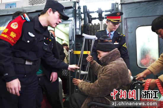 图为:乘警帮助旅客。中新社发 贺瑞明 摄