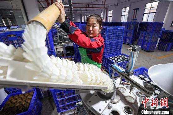 图为工人在加工羽毛球。中新社记者 瞿宏伦 摄
