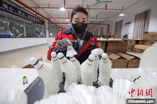图为工人对羽毛球进行最后质检。中新社记者 瞿宏伦 摄