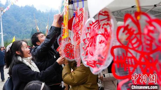 图为民众在榕江县四格苗寨迎元宵节活动中欣赏剪纸艺术。韦贵金 摄 图为民众在榕江县四格苗寨迎元宵节活动中欣赏剪纸艺术。韦贵金 摄
