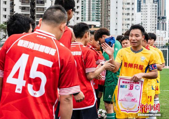 图为贵州村超队（黄衣）与穗港澳联队赛前握手致意。