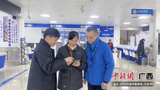 政务大厅工作人员和移动工作人员手把手教办事群众使用智能政务AI查询助手。 韦姣艳 摄 政务大厅工作人员和移动工作人员手把手教办事群众使用智能政务AI查询助手。 韦姣艳 摄