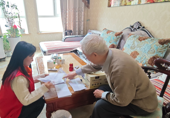 国网新疆培训中心青年员工上门服务退休员工,帮助整理和提交医疗票据。王崇龙 摄 国网新疆培训中心青年员工上门服务退休员工,帮助整理和提交医疗票据。王崇龙 摄