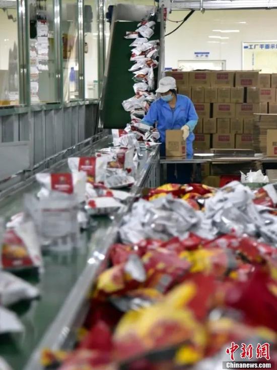 图为柳州市的一家预包装(袋装)螺蛳粉企业内,工人们正在生产备货。中新社记者 王以照 摄