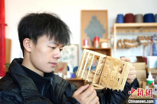 图为杨文建在展示创作的立体书。周燕玲 摄 图为杨文建在展示创作的立体书。周燕玲 摄