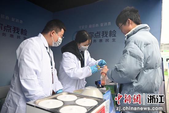 图为:工作人员为市民检测食物。中新社记者 王刚 摄