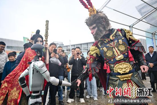 图为:《黑神话:悟空》人偶和人形机器人互动,带动活动现场氛围。中新社记者 王刚 摄