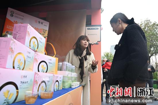 图为:展位工作人员向市民介绍保健茶饮。中新社记者 王刚 摄
