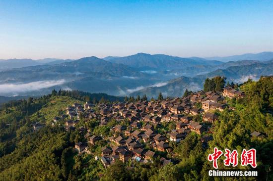 从江县丙妹镇岜沙苗寨，村民在向游客展示传统的“镰刀剃头”技艺。张素 摄