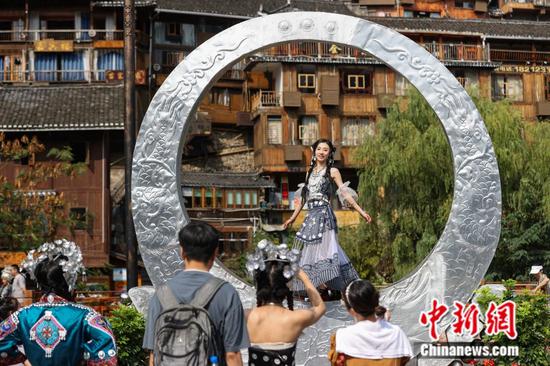 游客在贵州西江千户苗寨游玩。 中新社记者 瞿宏伦 摄