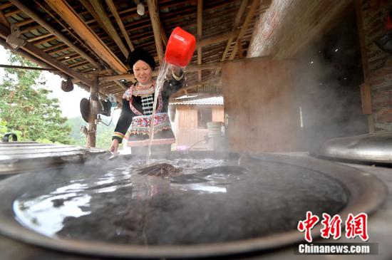 贵州省从江县丙妹镇大塘村五里坡瑶寨的村民在舀药水准备给客人洗浴。吴德军 摄