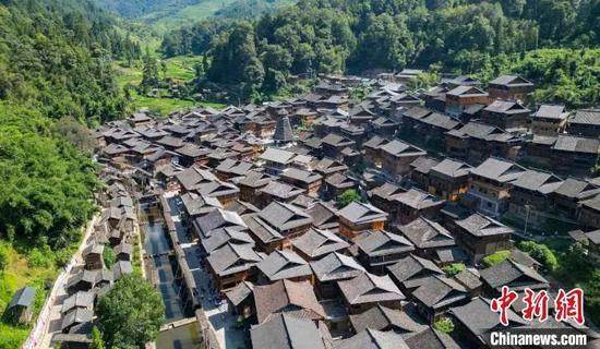 图为航拍中国传统村落占里侗寨，民居与道路、青山相映成景。卢忠南 摄