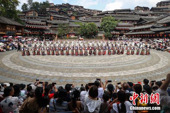 游客在贵州西江千户苗寨游玩。中新社记者 瞿宏伦 摄