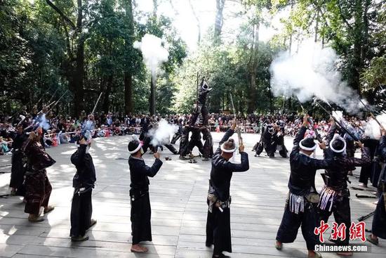 岜沙苗寨村民用火枪为游客表演。中新社记者 侯宇 摄