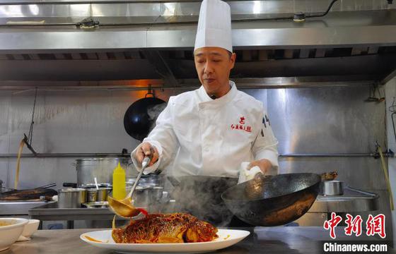 1月22日,罗林完成罾蹦鲤鱼的最后一个步骤,以“热汁儿”浇“热鱼”。杨子炀 摄 1月22日,罗林完成罾蹦鲤鱼的最后一个步骤,以“热汁儿”浇“热鱼”。杨子炀 摄